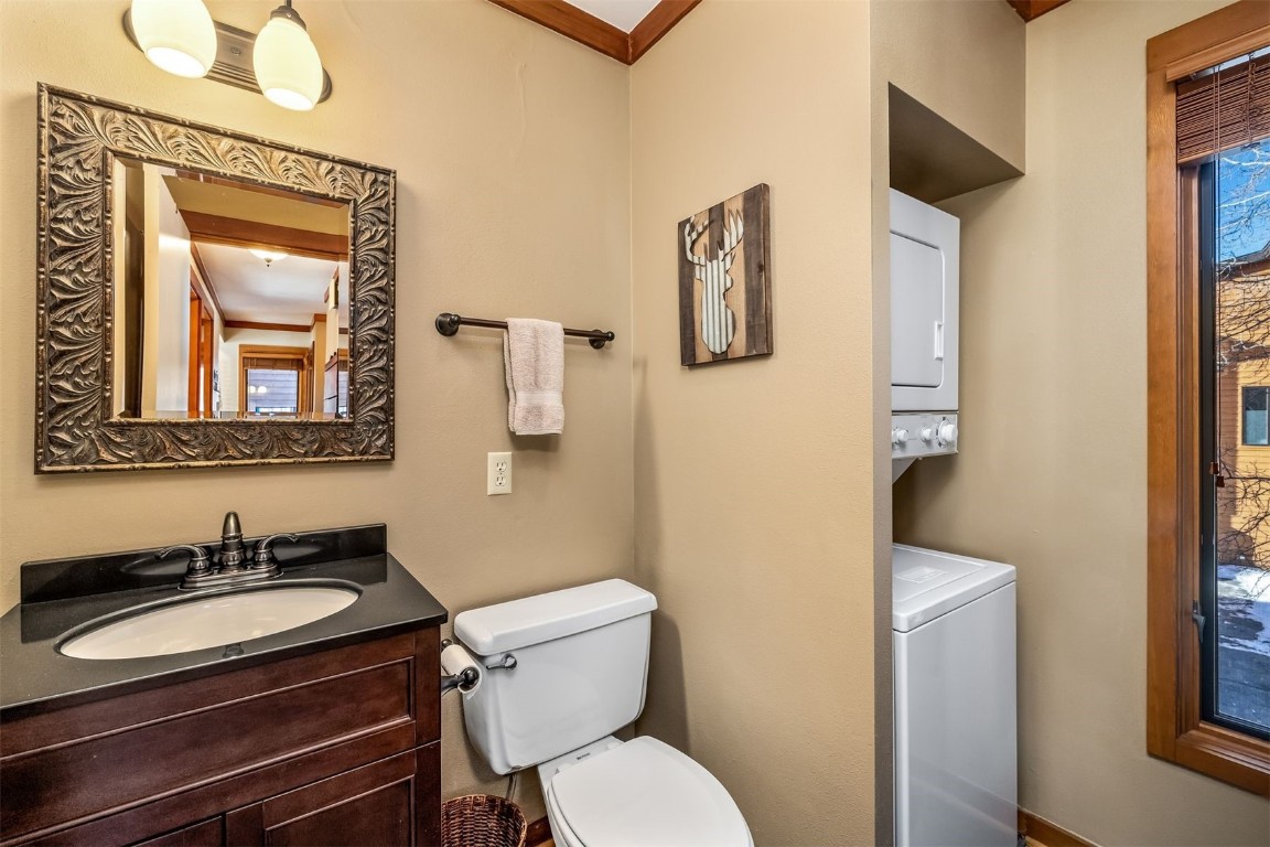 410 Tennis Club Road, Unit 1317 Keystone, CO 80435 - Photo 9 of 47 Bathroom with vanity, stacked washer / drying machine, and crown molding