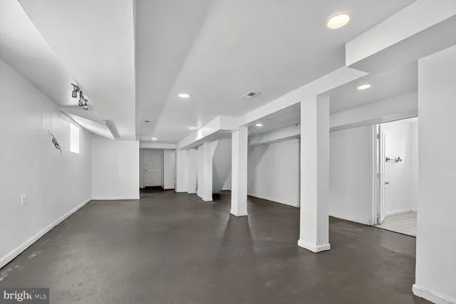 an empty room with a cabinet and mirrors