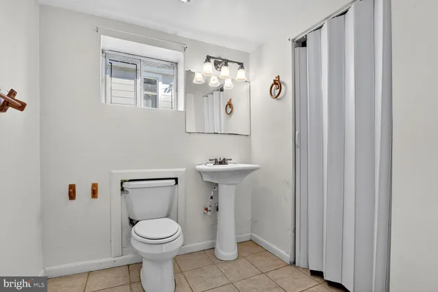 a bathroom with a toilet sink and mirror