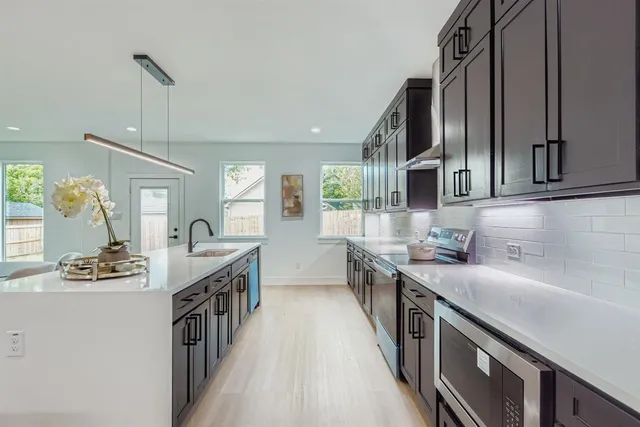 a kitchen with stainless steel appliances a sink stove and cabinets