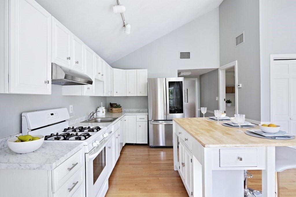 206 West Street Reading, MA 01867 - Photo 3 of 28 a kitchen with a sink stove and wooden cabinets