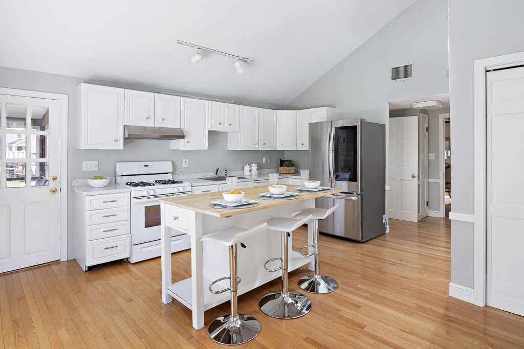 206 West Street Reading, MA 01867 - Photo 5 of 28 a kitchen with stainless steel appliances a stove a sink cabinets and wooden floor