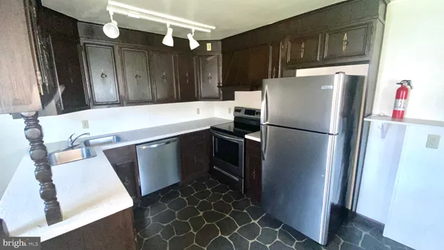 a kitchen with a refrigerator sink and cabinets