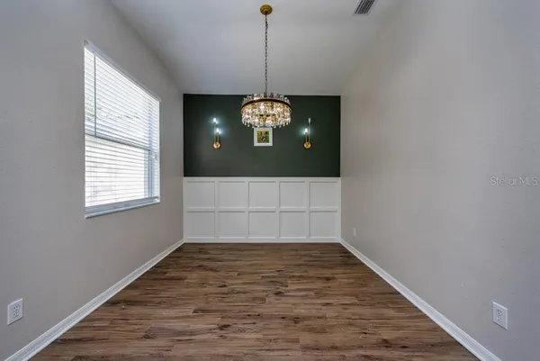 a view of a room with window wooden floor and chandelier