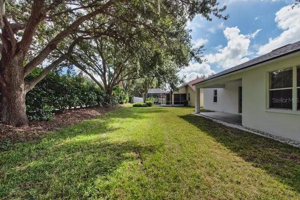 a view of a house with backyard and trees