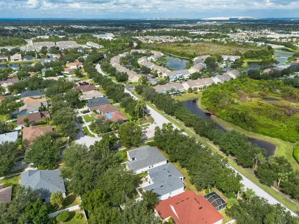 an aerial view of residential houses with outdoor space and trees