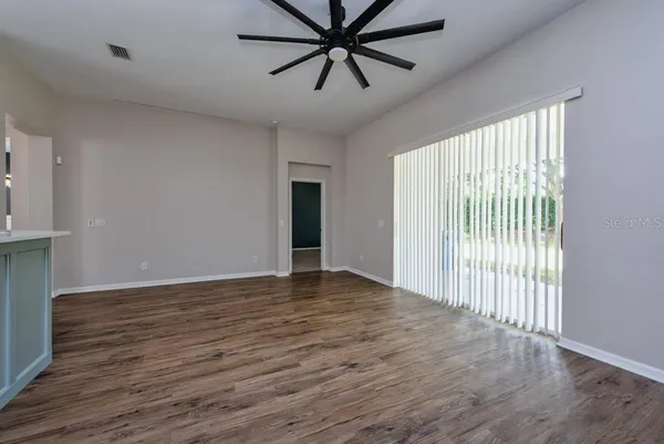 a view of a livingroom with a ceiling fan and wooden floor