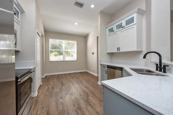 a view of a kitchen with sink dishwasher and wooden floor