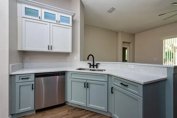 a kitchen with white cabinets sink and dishwasher