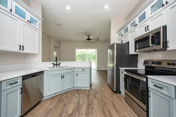 a kitchen with stainless steel appliances a stove microwave and sink