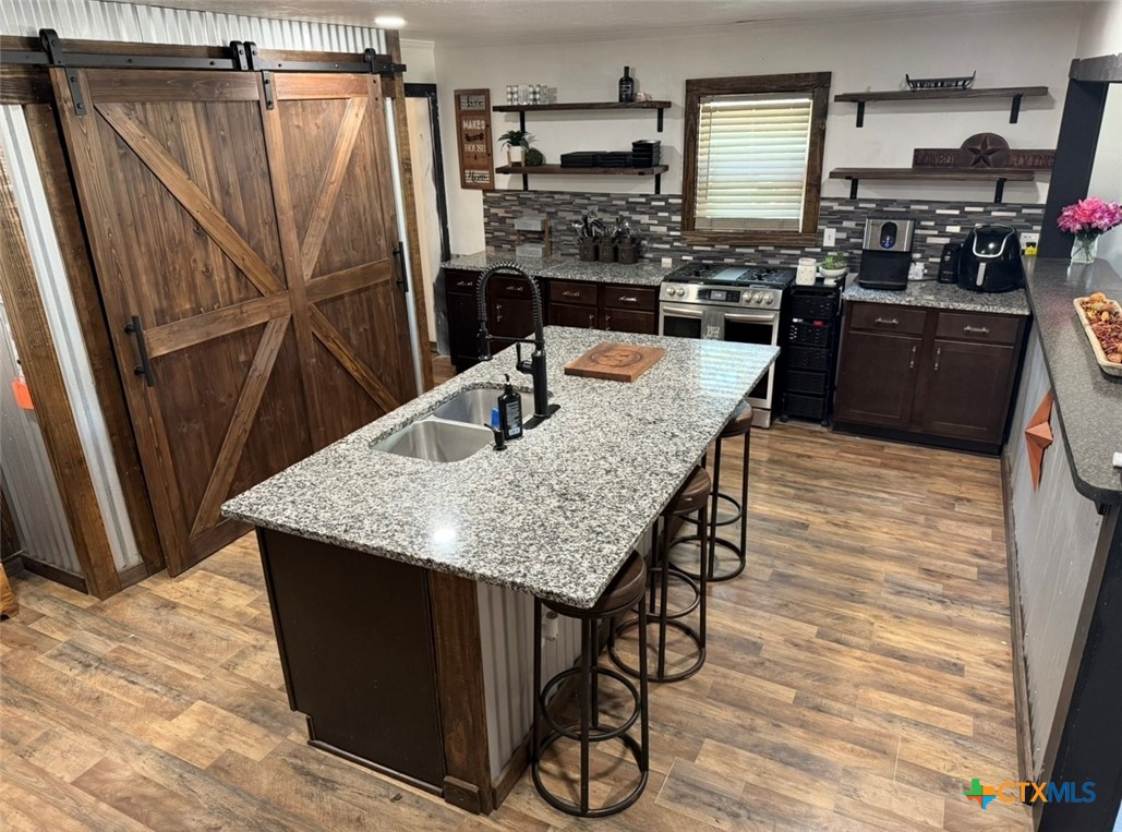 202 Clark Street Yoakum, TX 77995 - Photo 2 of 15 a kitchen with stainless steel appliances granite countertop a refrigerator a stove and a wooden floors