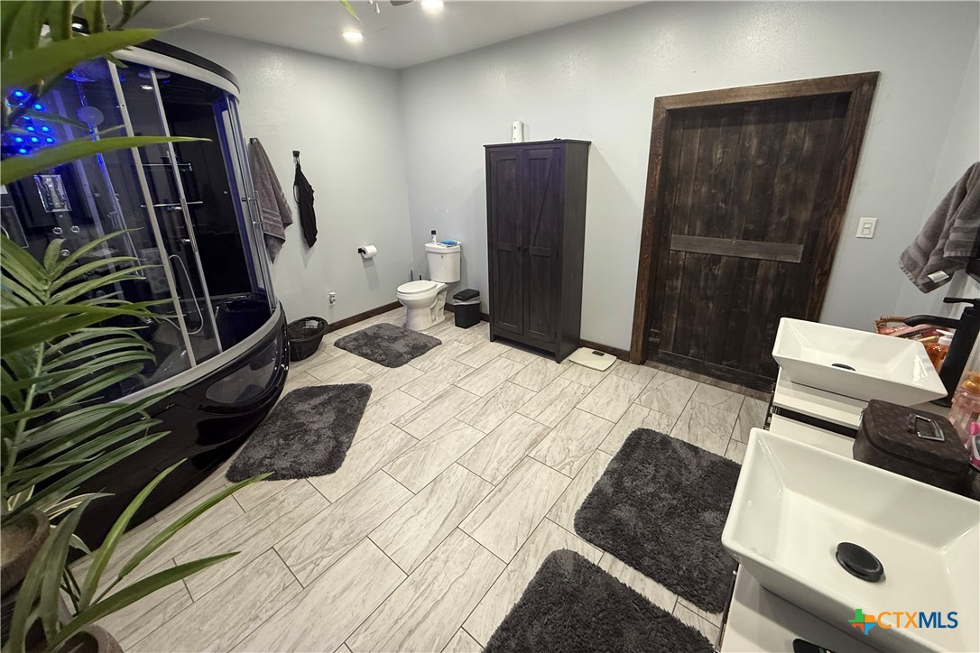 202 Clark Street Yoakum, TX 77995 - Photo 8 of 15 a bedroom with a bed and a flat screen tv