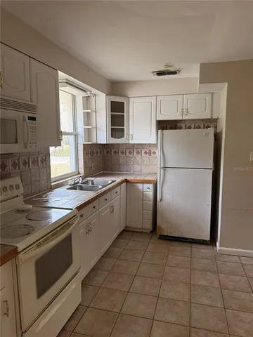 a kitchen with a stove a refrigerator and a sink