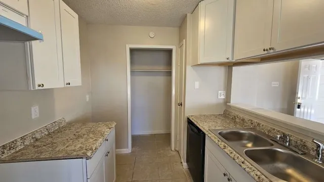 a kitchen with granite countertop stainless steel appliances a sink stove and cabinets