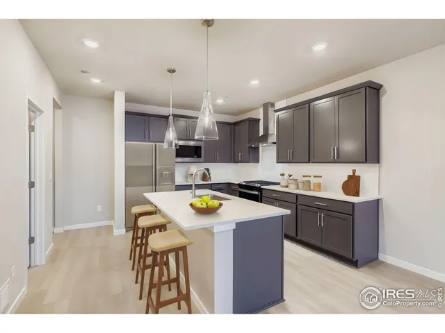 a kitchen with stainless steel appliances kitchen island granite countertop a stove a sink a microwave and a refrigerator