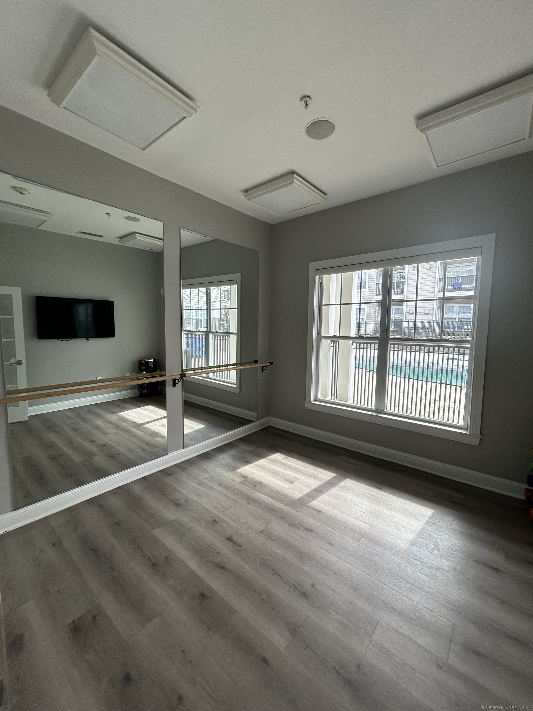 138 Hollow Tree Ridge Road, Unit 1802 Darien, CT 06820 - Photo 15 of 30 a view of an empty room with wooden floor and a window