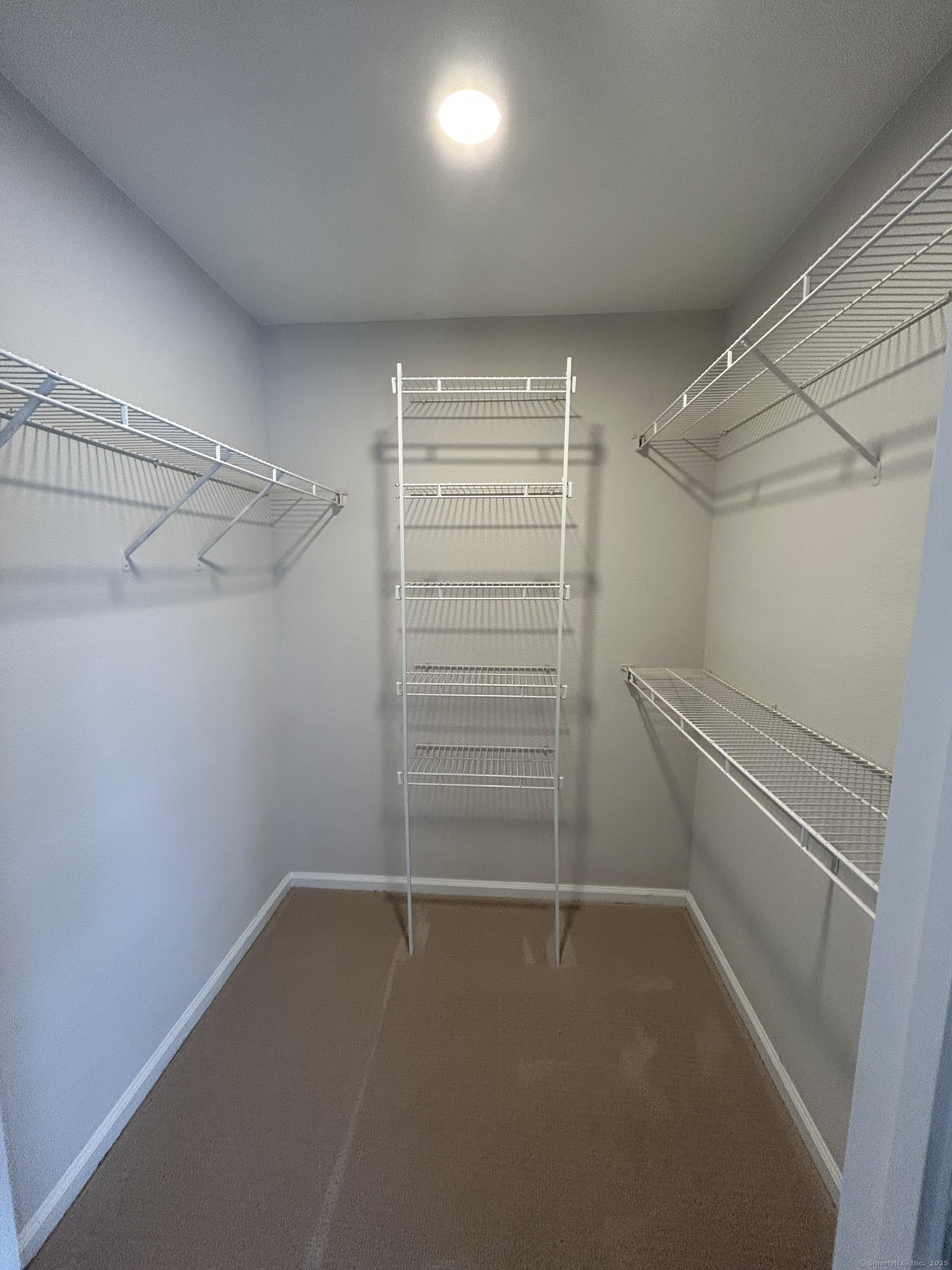 138 Hollow Tree Ridge Road, Unit 1802 Darien, CT 06820 - Photo 9 of 30 a view of walk in closet with empty racks