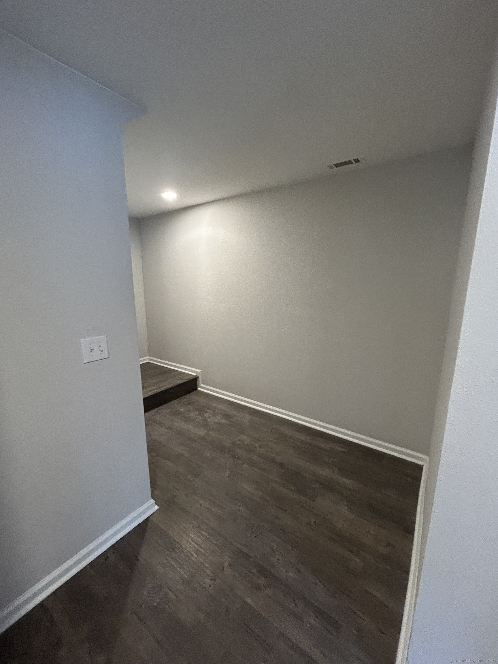 138 Hollow Tree Ridge Road, Unit 1802 Darien, CT 06820 - Photo 10 of 30 an empty room with wooden floor and windows