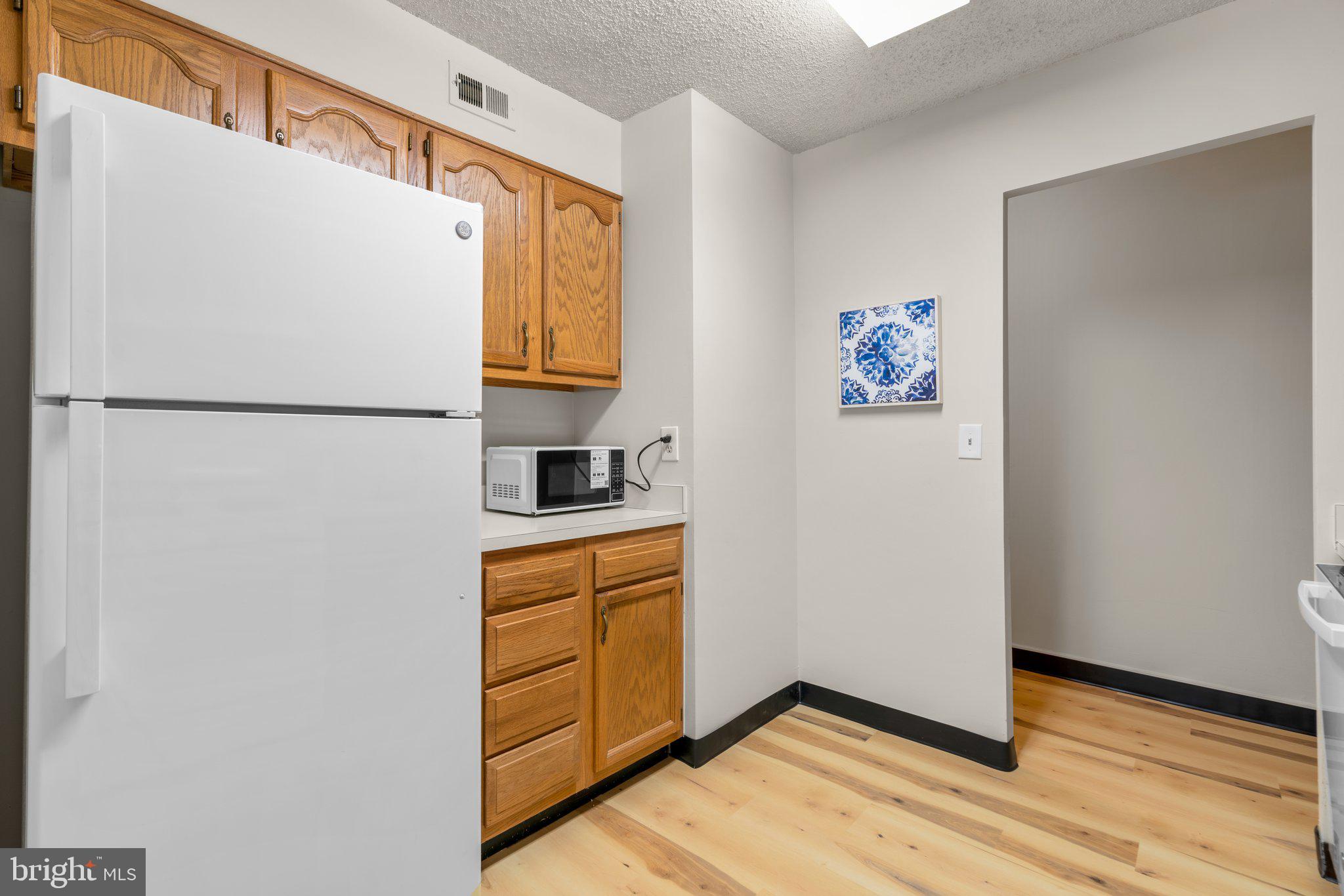 5907 Tamar Drive, Unit 7 R7 Columbia, MD 21045 - Photo 9 of 23 a white refrigerator freezer sitting inside of a kitchen