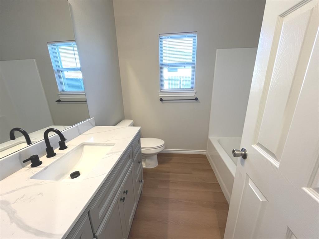 316 James Street Mabank, TX 75147 - Photo 11 of 20 a bathroom with a sink a toilet and a window