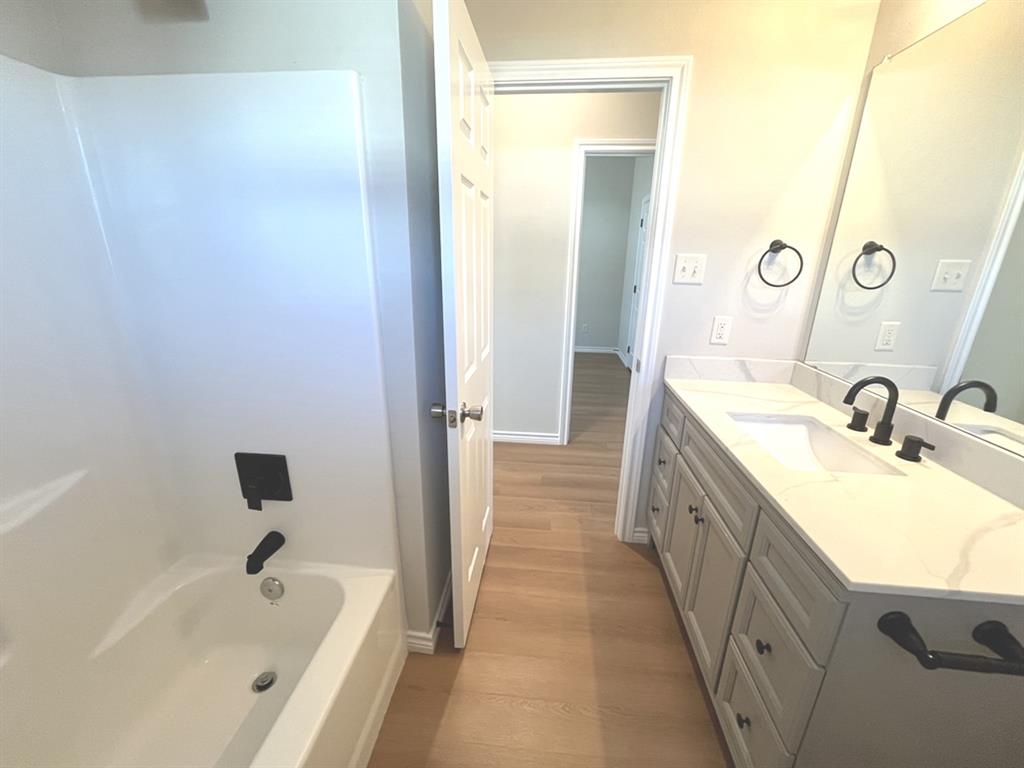 316 James Street Mabank, TX 75147 - Photo 12 of 20 a bathroom with a tub sink and mirror