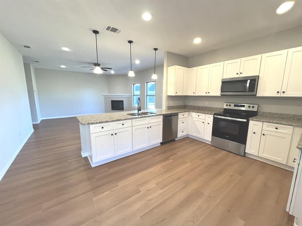 316 James Street Mabank, TX 75147 - Photo 5 of 20 a large kitchen with cabinets a sink and a stove