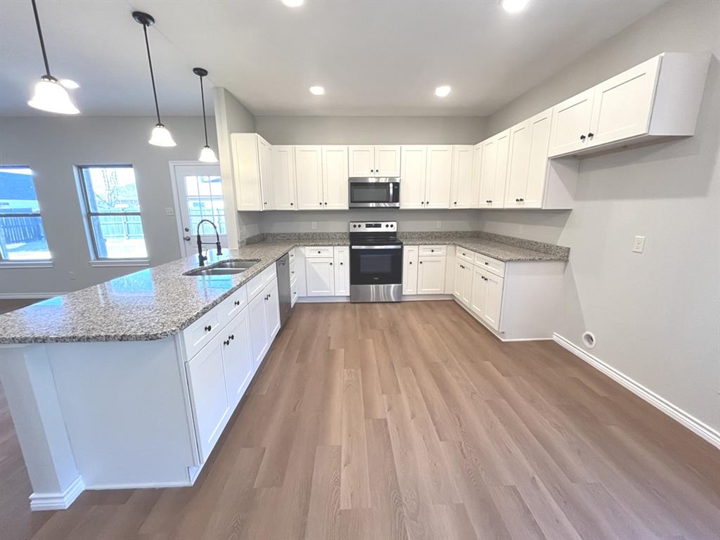 316 James Street Mabank, TX 75147 - Photo 6 of 20 a large kitchen with granite countertop a large counter top a sink stainless steel appliances and cabinets