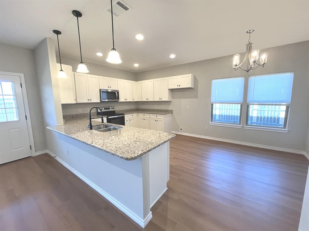 316 James Street Mabank, TX 75147 - Photo 7 of 20 a kitchen with kitchen island granite countertop a sink a counter space appliances and cabinets