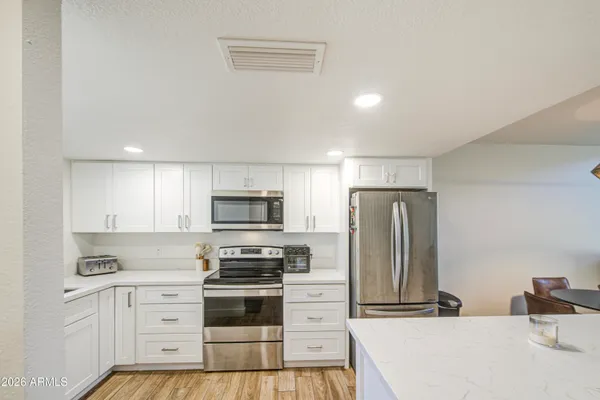 a kitchen with white cabinets sink and stainless steel appliances