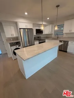 a kitchen with stainless steel appliances granite countertop a sink a stove and a refrigerator