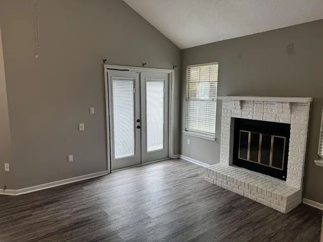 a view of a livingroom with wooden floor and a fireplace