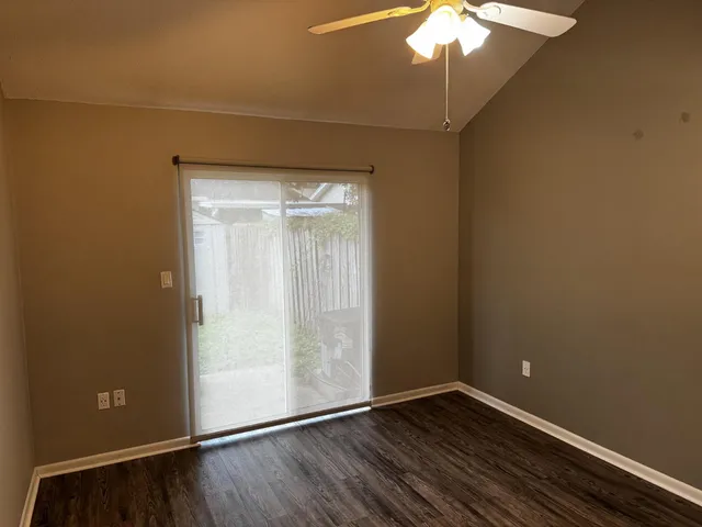 en empty room with wooden floor and fan