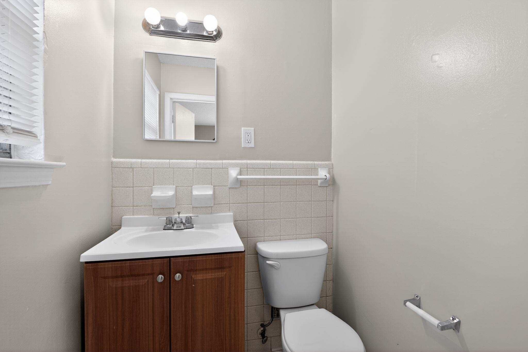 3637 Neely Road Memphis, TN 38109 - Photo 24 of 30 Bathroom with vanity, tile walls, and a wainscoted wall