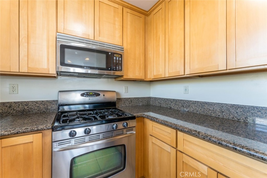 511 East Harvard Road, Unit 101 Burbank, CA 91501 - Photo 13 of 29 a kitchen with granite countertop cabinets stainless steel appliances and a counter space
