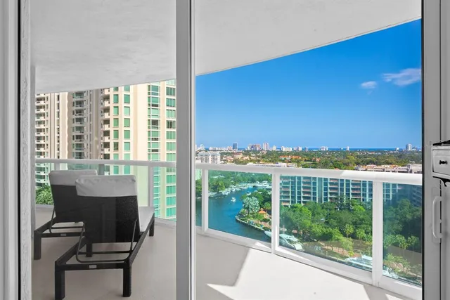 a living room with furniture floor to ceiling window and a rug