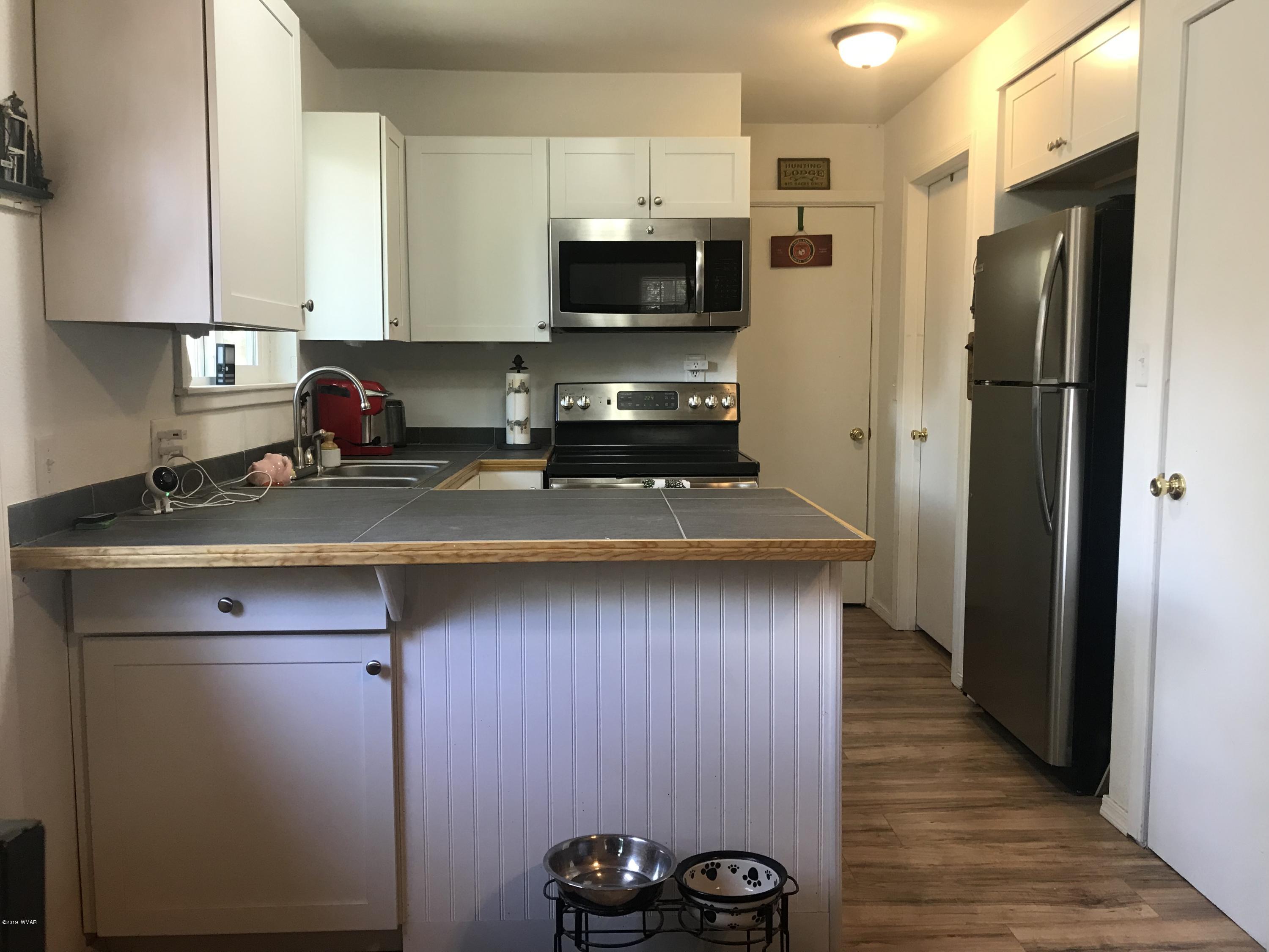 2883 Belle Road Overgaard, AZ 85933 - Photo 6 of 13 a kitchen with a refrigerator and a stove top oven