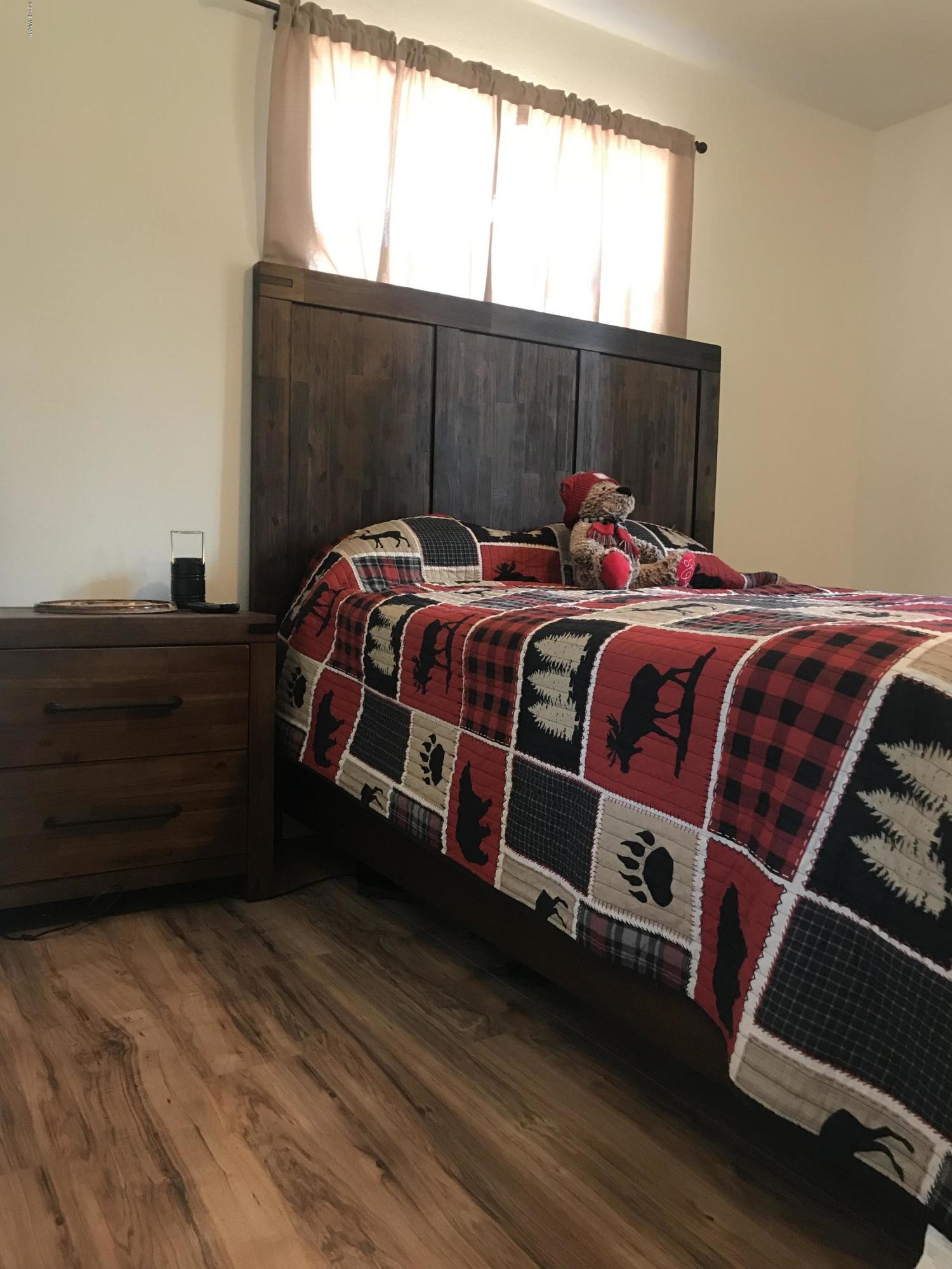 2883 Belle Road Overgaard, AZ 85933 - Photo 10 of 13 a bed sitting in a bedroom next to a window
