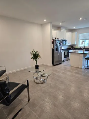 a kitchen with stainless steel appliances kitchen island granite countertop a stove a refrigerator and a sink