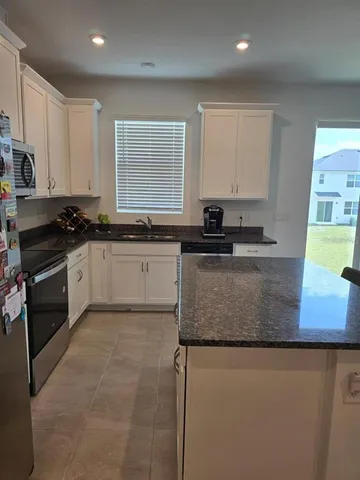 a kitchen with stainless steel appliances granite countertop a sink stove and cabinets