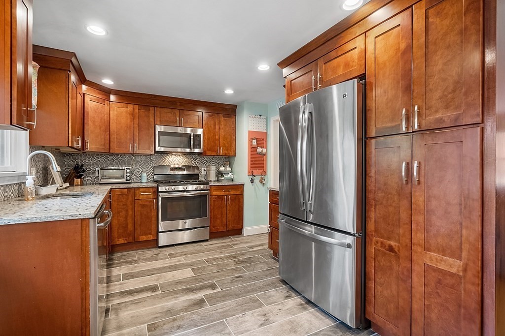 13 Clinton Road Peabody, MA 01960 - Photo 4 of 39 a kitchen with granite countertop stainless steel appliances a refrigerator stove top oven and sink