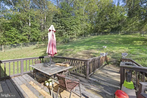 a view of a deck with a table and chairs with wooden floor and fence