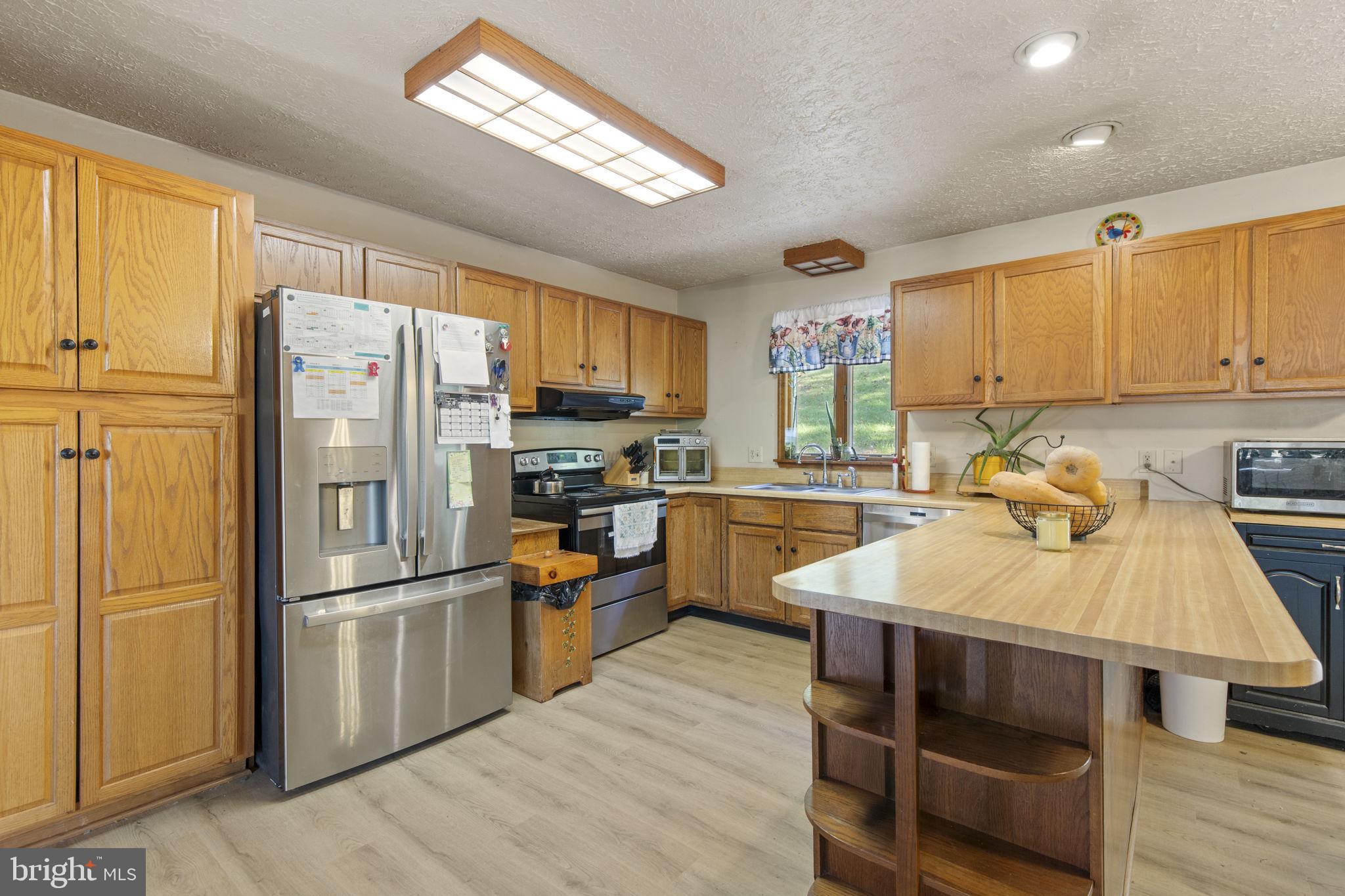 62 Porters Bridge Road Colora, MD 21917 - Photo 5 of 29 a kitchen with granite countertop a refrigerator a sink dishwasher a stove and white cabinets with wooden floor