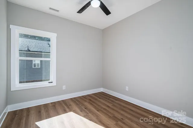 an empty room with a window and wooden floor