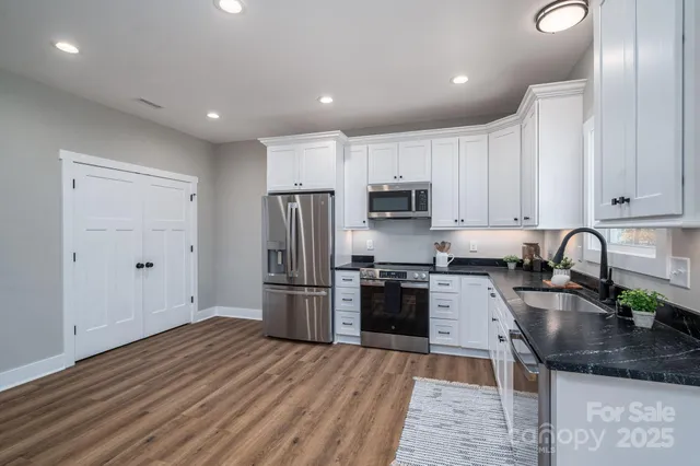a kitchen with stainless steel appliances granite countertop a refrigerator sink and stove