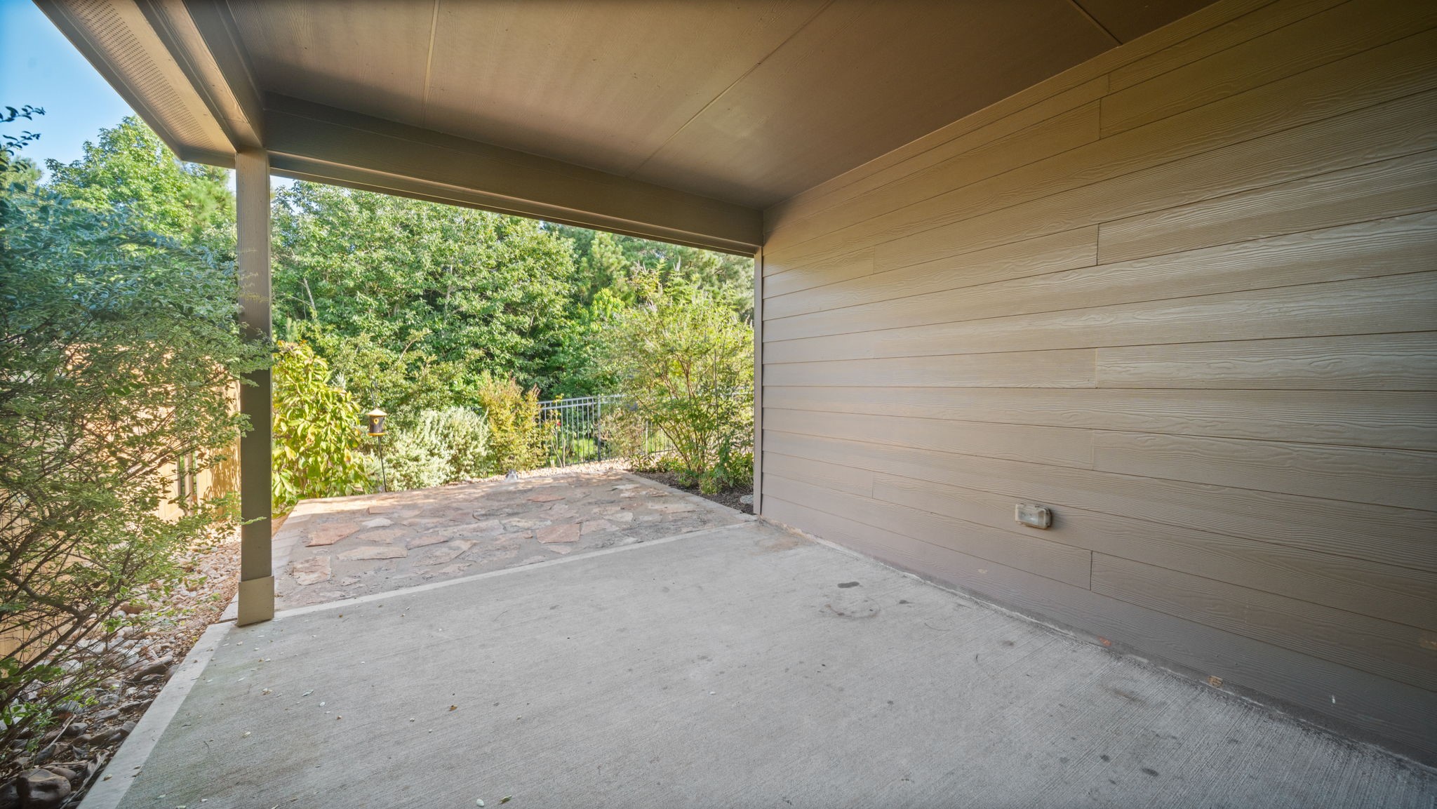 12348 Delta Timber Road Conroe, TX 77304 - Photo 20 of 22 Relax year-round on the covered back patio overlooking the beautifully landscaped backyard—an ideal space for outdoor dining, entertaining, or simply enjoying the peaceful setting.