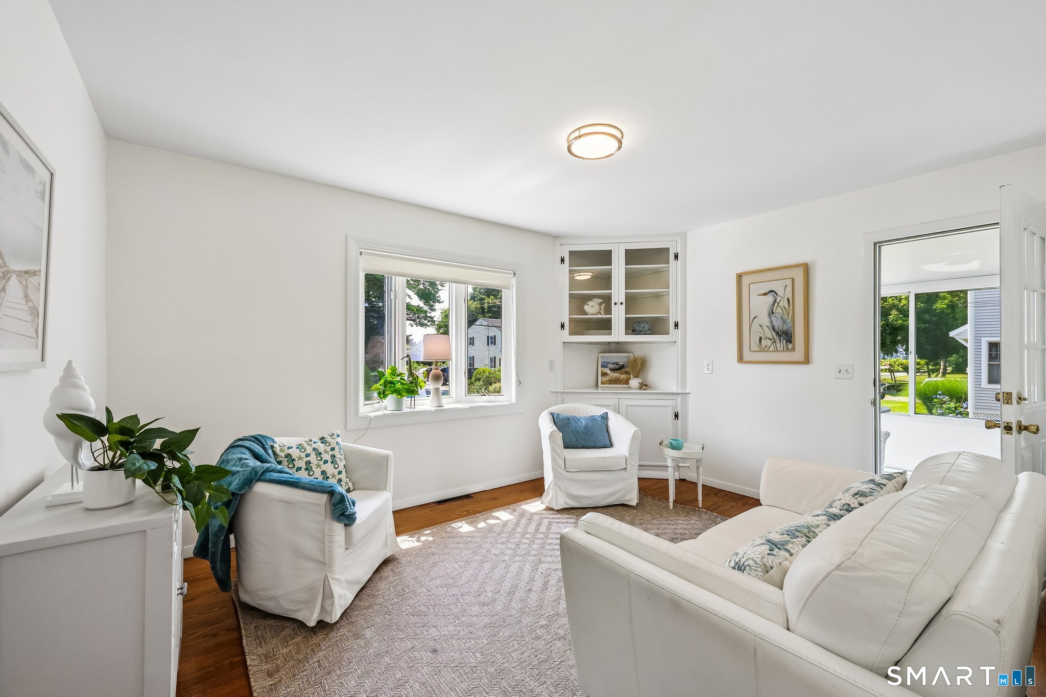 53 Chalker Beach Road Old Saybrook, CT 06475 - Photo 5 of 24 Living room has access into enclosed sunroom with glass windows and sliding glass door.