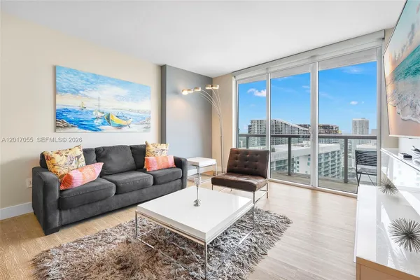 a living room with furniture and a floor to ceiling window