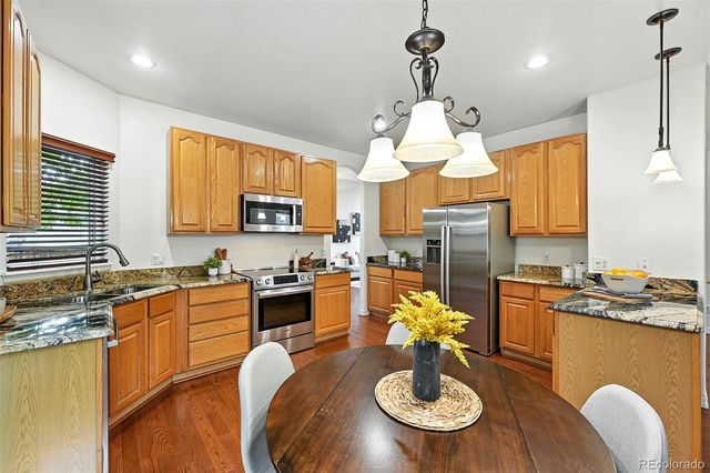 a kitchen with a stove a dining table and chairs