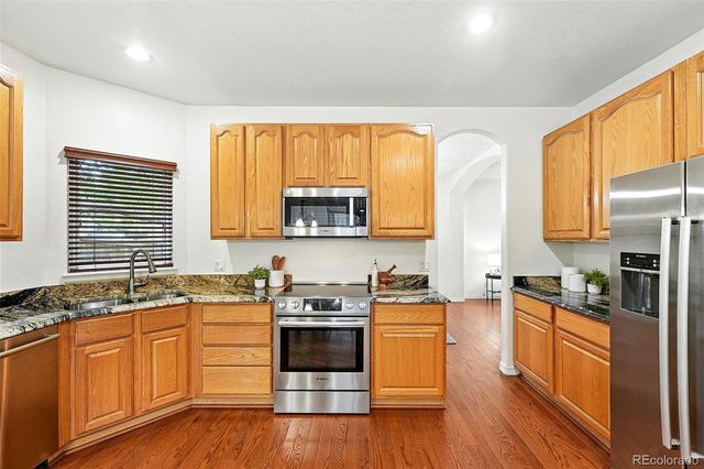 a kitchen with stainless steel appliances a stove a sink a refrigerator and cabinets