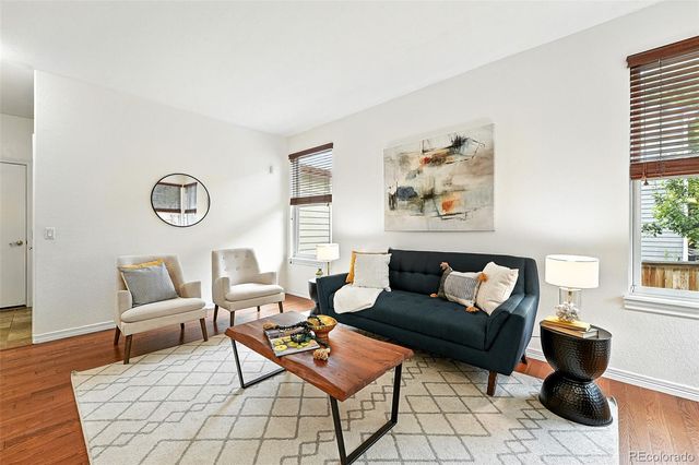 a living room with furniture and wooden floor